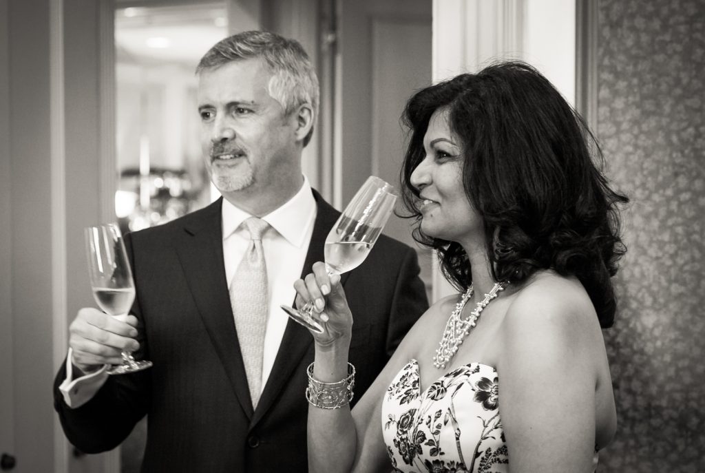 Black and white photo of bride and groom holding champagne glasses