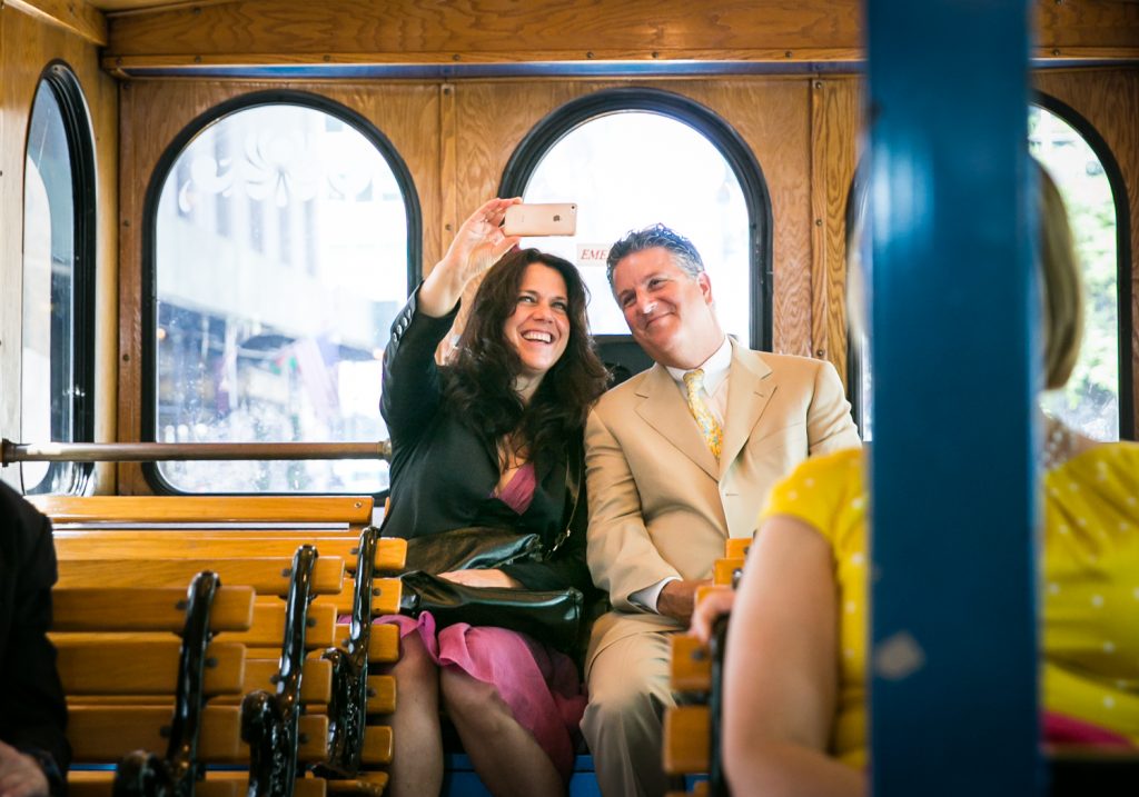 Couple taking selfie with cell phone on board trolley