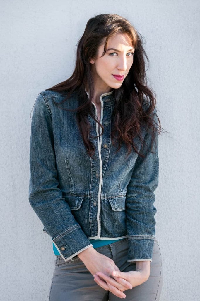 Headshot of model with long dark hair and jean jacket