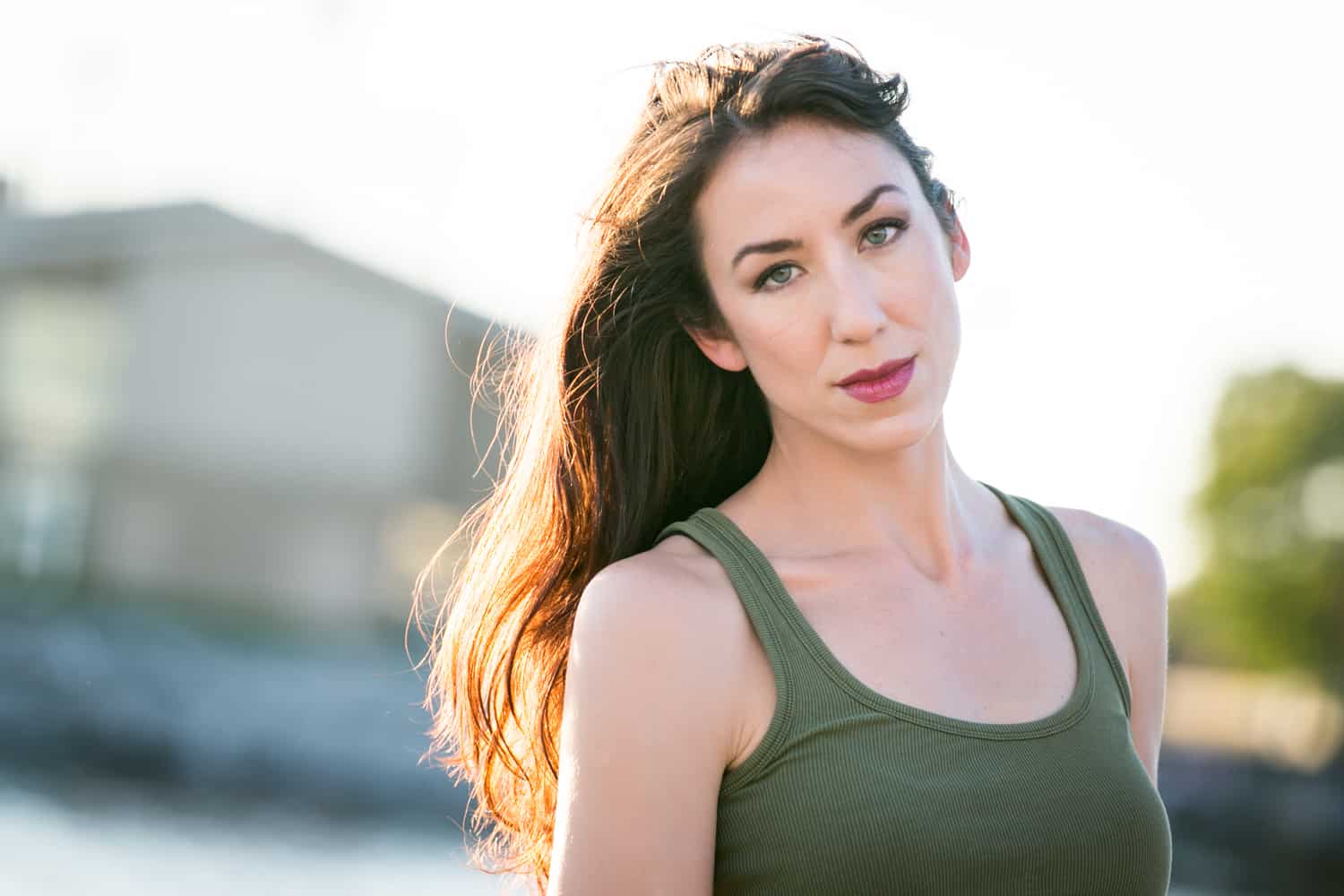 Acting headshot of model with long dark hair and olive tank top