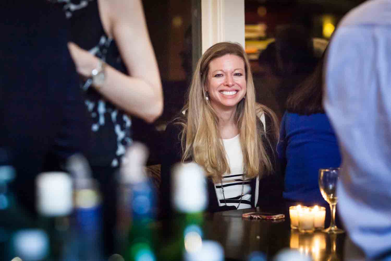 Birthday party photos of woman with blond hair smiling over bar