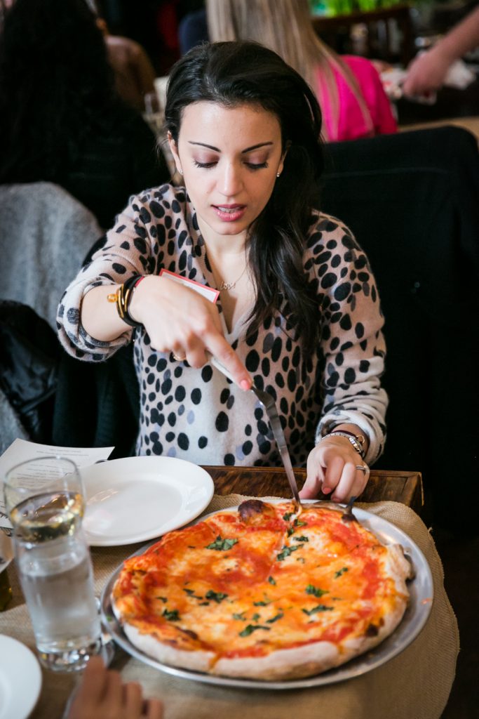 Woman cutting pizza at a NYC bridal shower