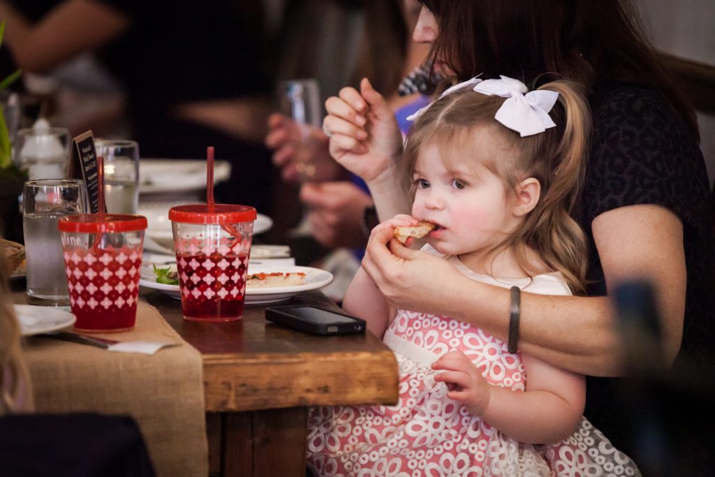 Hand feeding little girl a snack at a NYC bridal shower