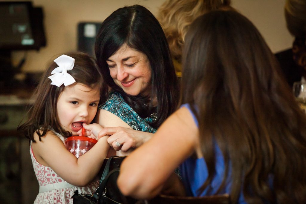 Woman looking over shoulder at child at a NYC bridal shower