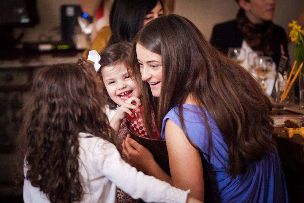 Girl chatting with two little girls at a NYC bridal shower