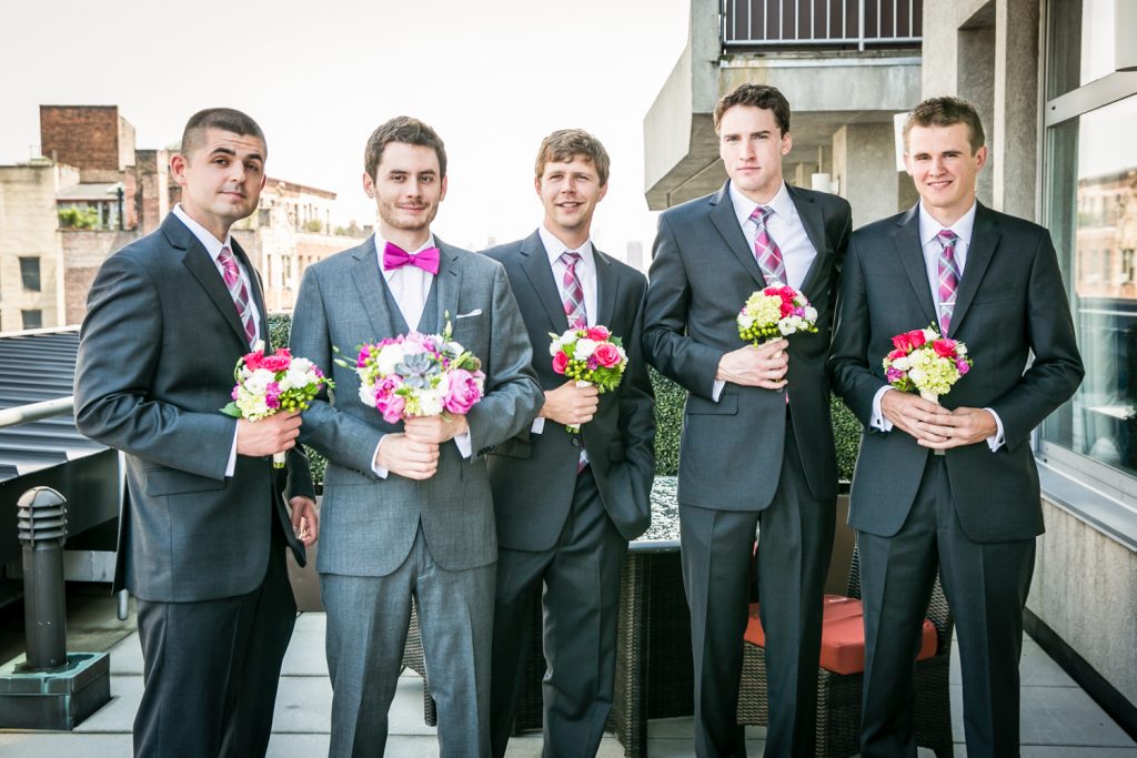 Portrait of groom and groomsmen holding bouquets for an article on how to get the wedding photos you want