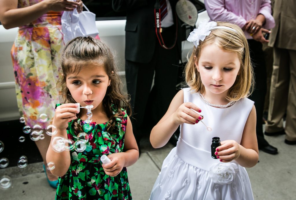 Two little girls blowing bubbles for an article on how to get the wedding photos you want