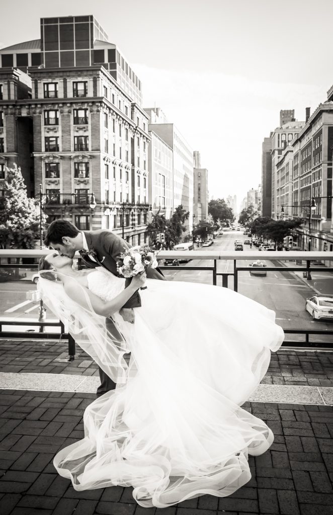 Groom dipping bride on NYC building rooftop