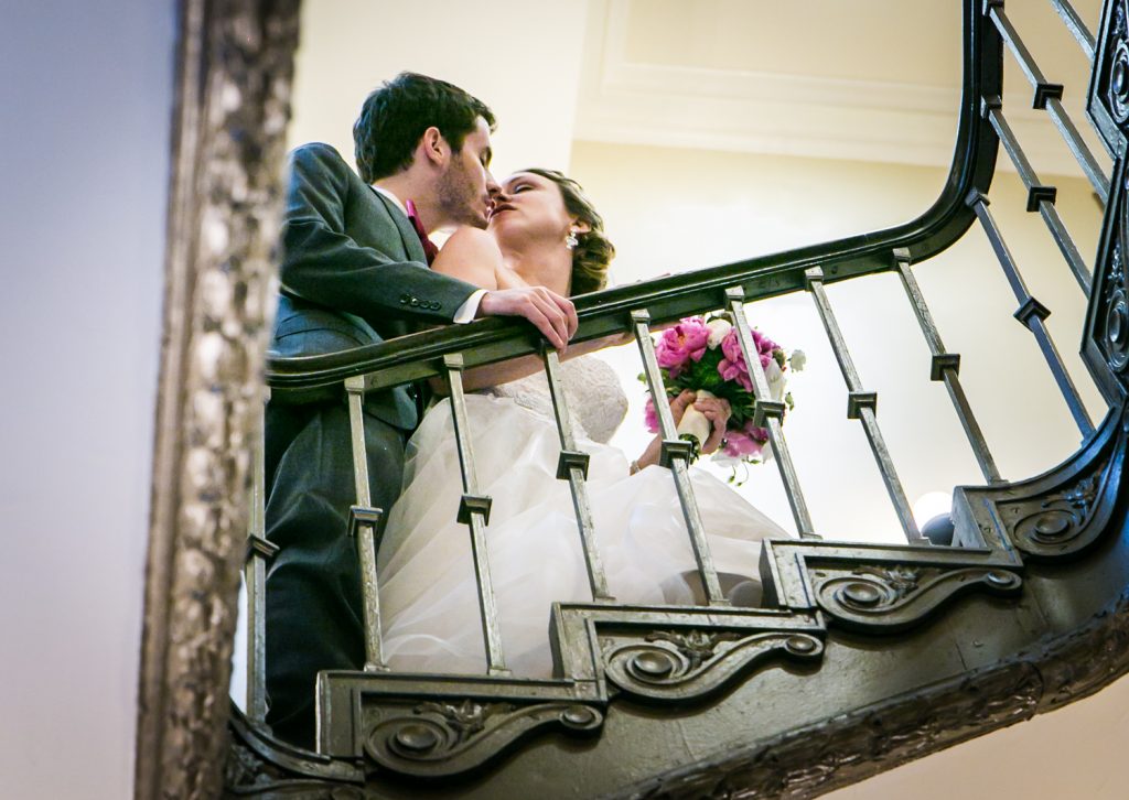 Bride and groom about to kiss on staircase for an article on how to get the wedding photos you want