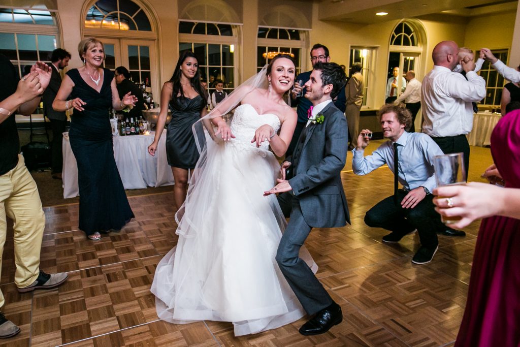 Bride and groom dancing within circle at wedding reception