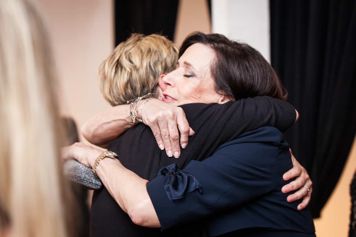 Two women hugging for an article on how to plan the perfect bar mitzvah