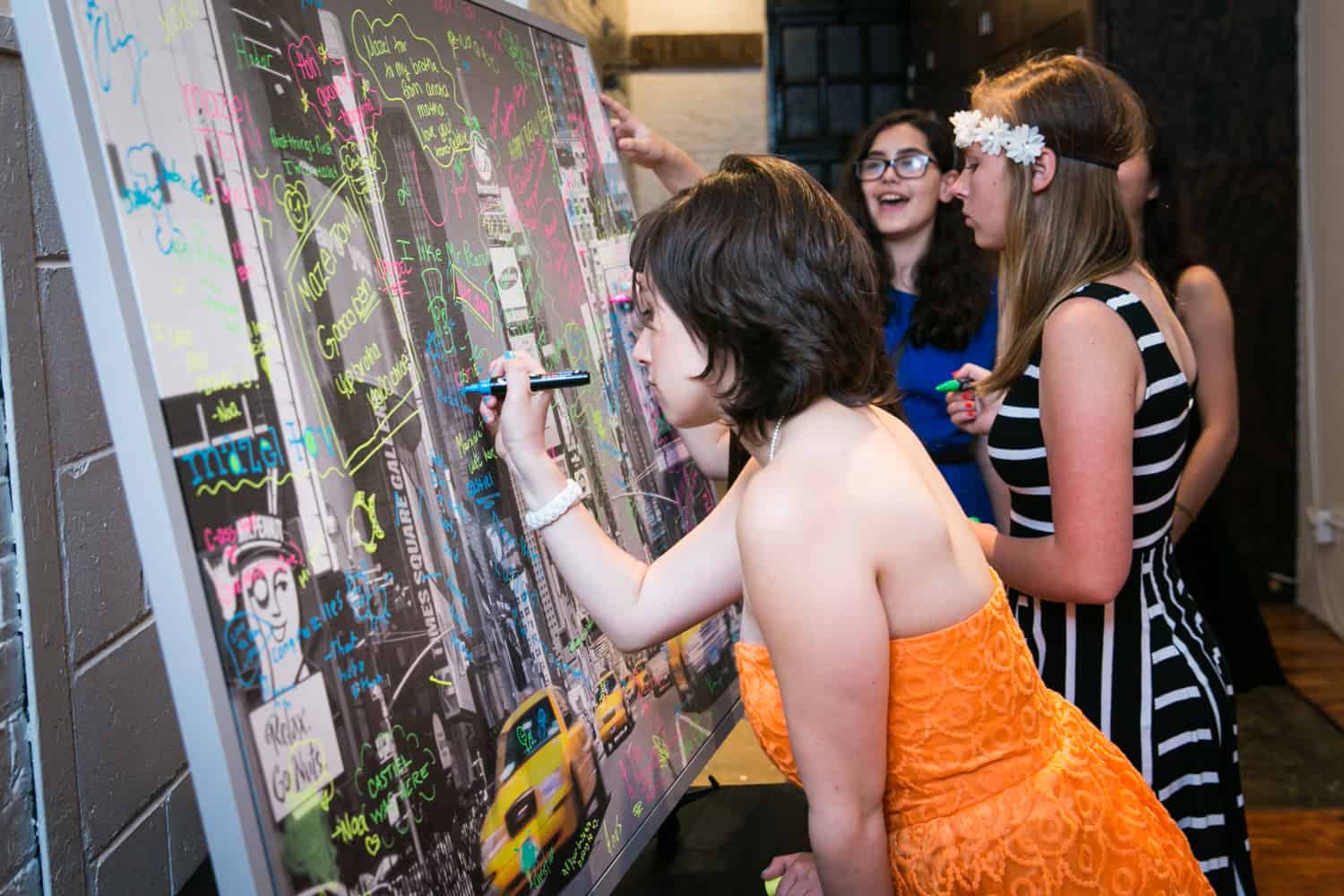 Girl signing framed guest book for an article on how to plan the perfect bar mitzvah