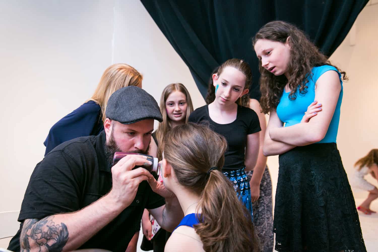 Guests watching as girl gets her face painted for an article on how to plan the perfect bar mitzvah