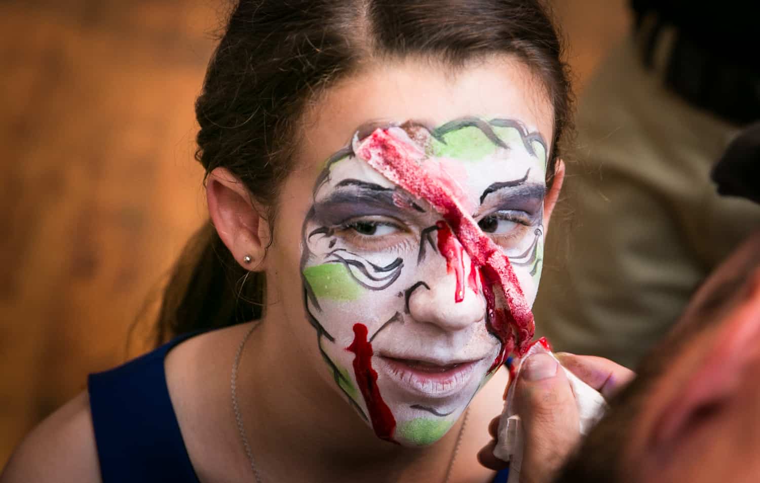 Close up of girl getting zombie makeup painted for an article on how to plan the perfect bar mitzvah