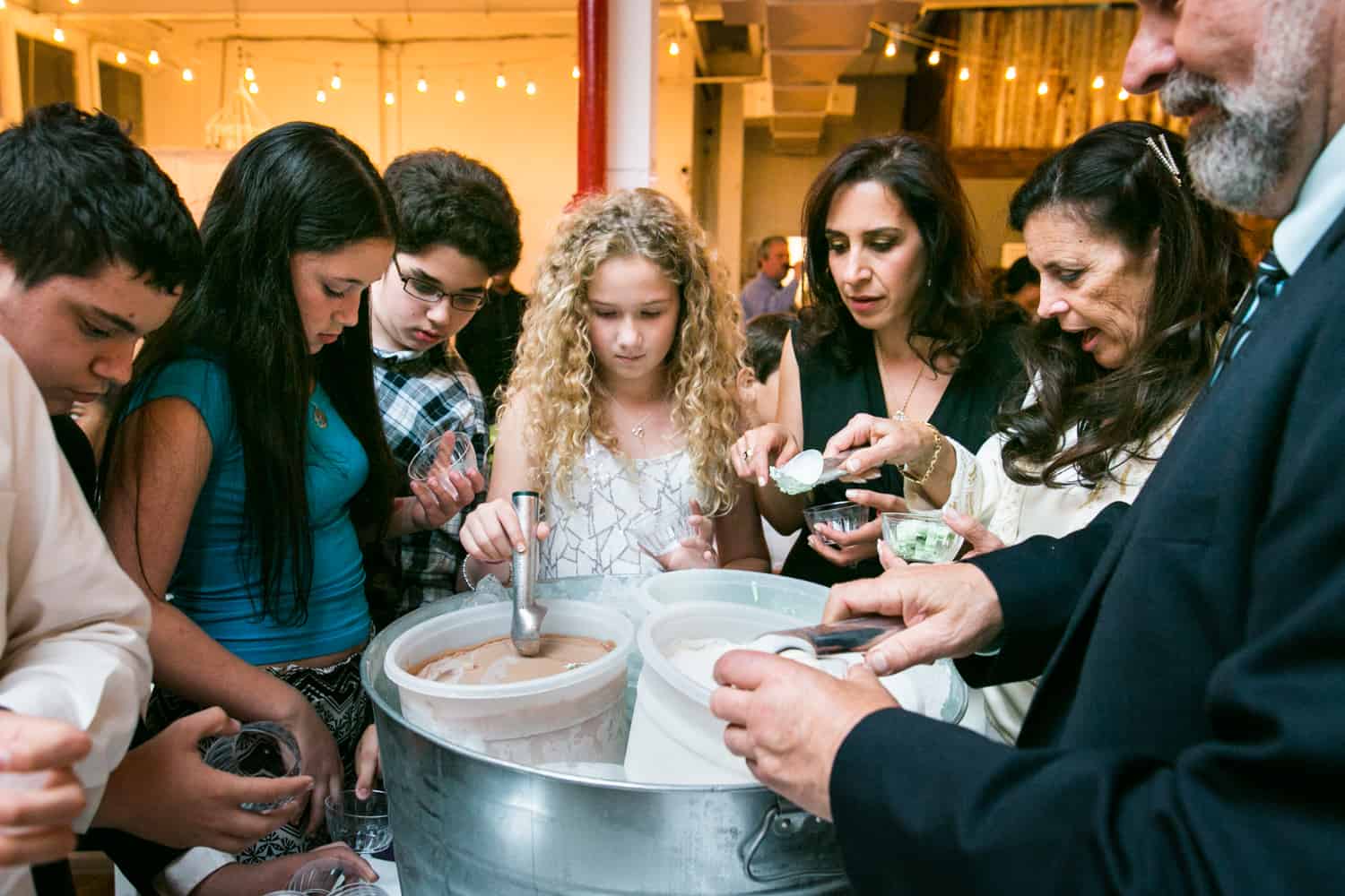 Guests surrounding tin full of ice cream for an article on how to plan the perfect bar mitzvah