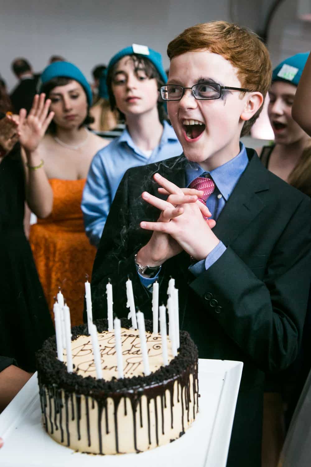 Boy celebrating after blowing out candles for an article on how to plan the perfect bar mitzvah