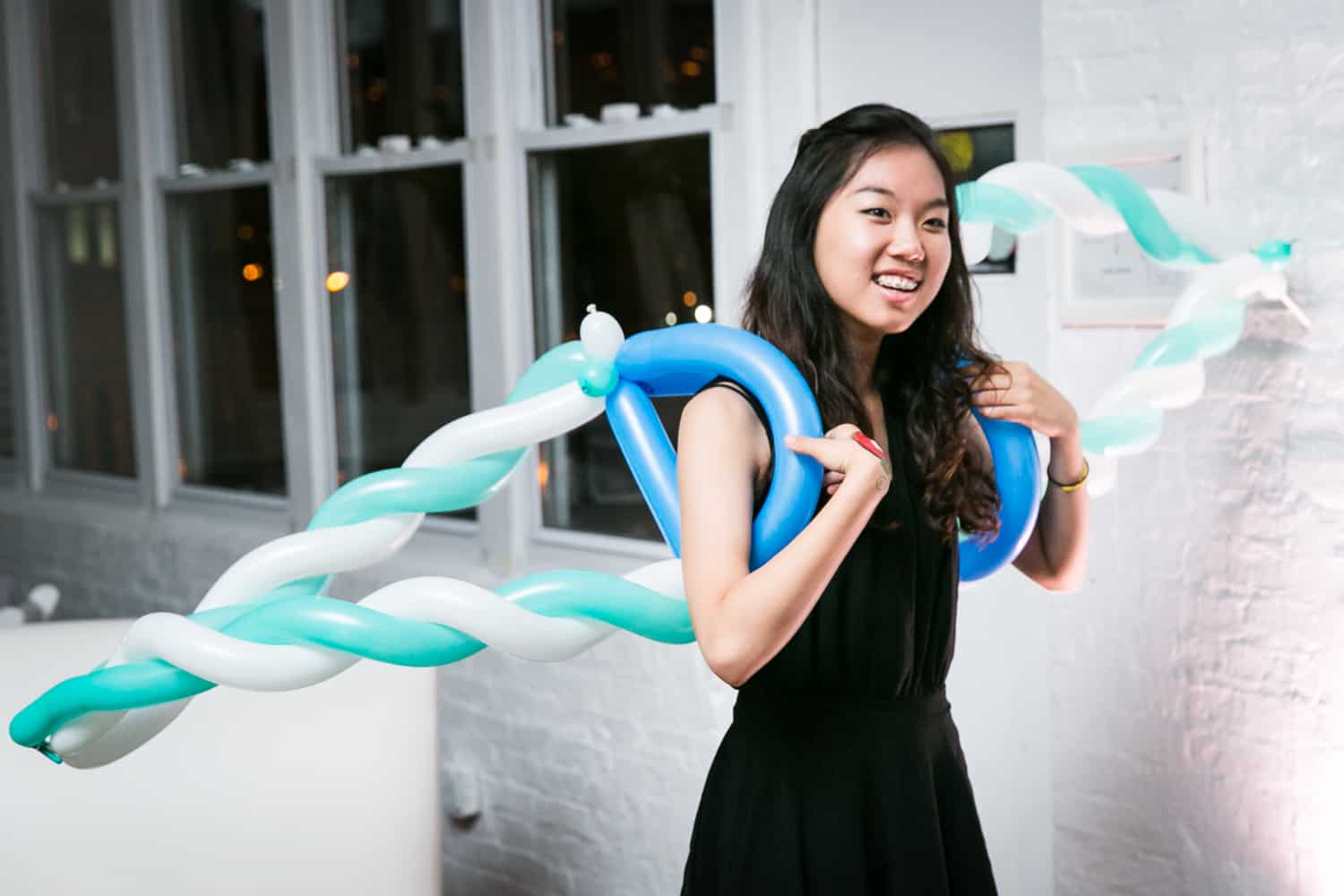 Girl with blue and white balloon wings for an article on how to plan the perfect bar mitzvah