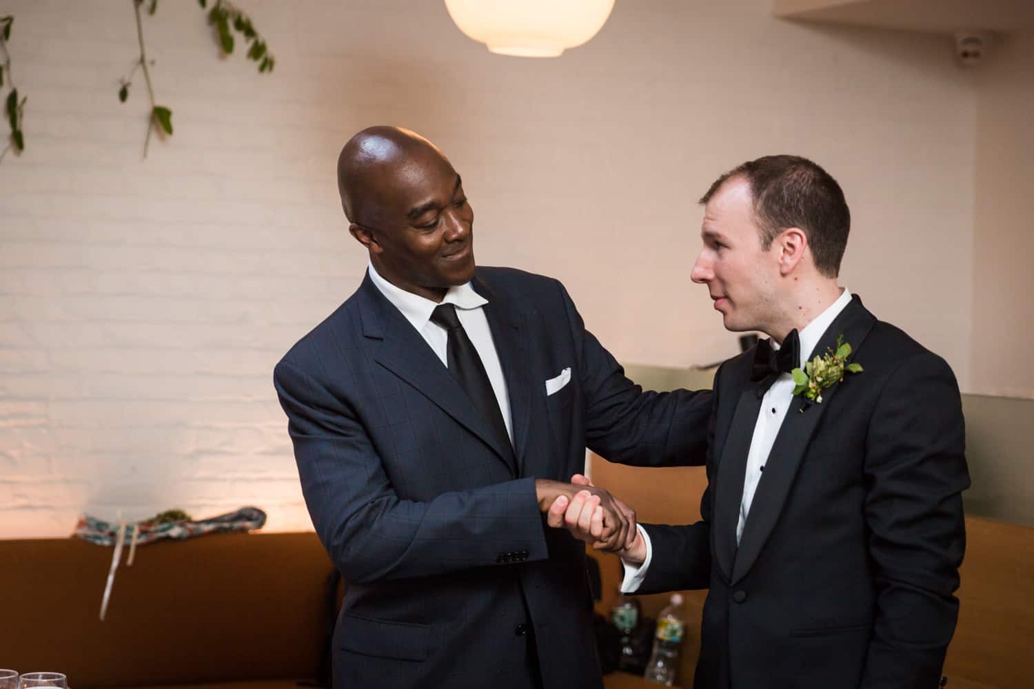 African American guest shaking hands with groom