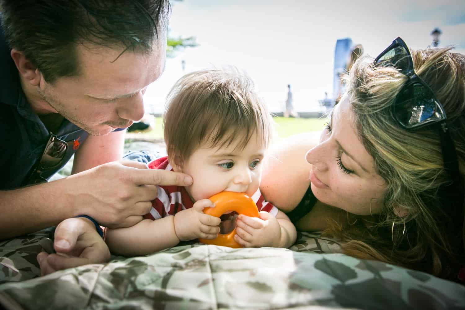 Parents playing with baby on blanket during a Battery Park family portrait