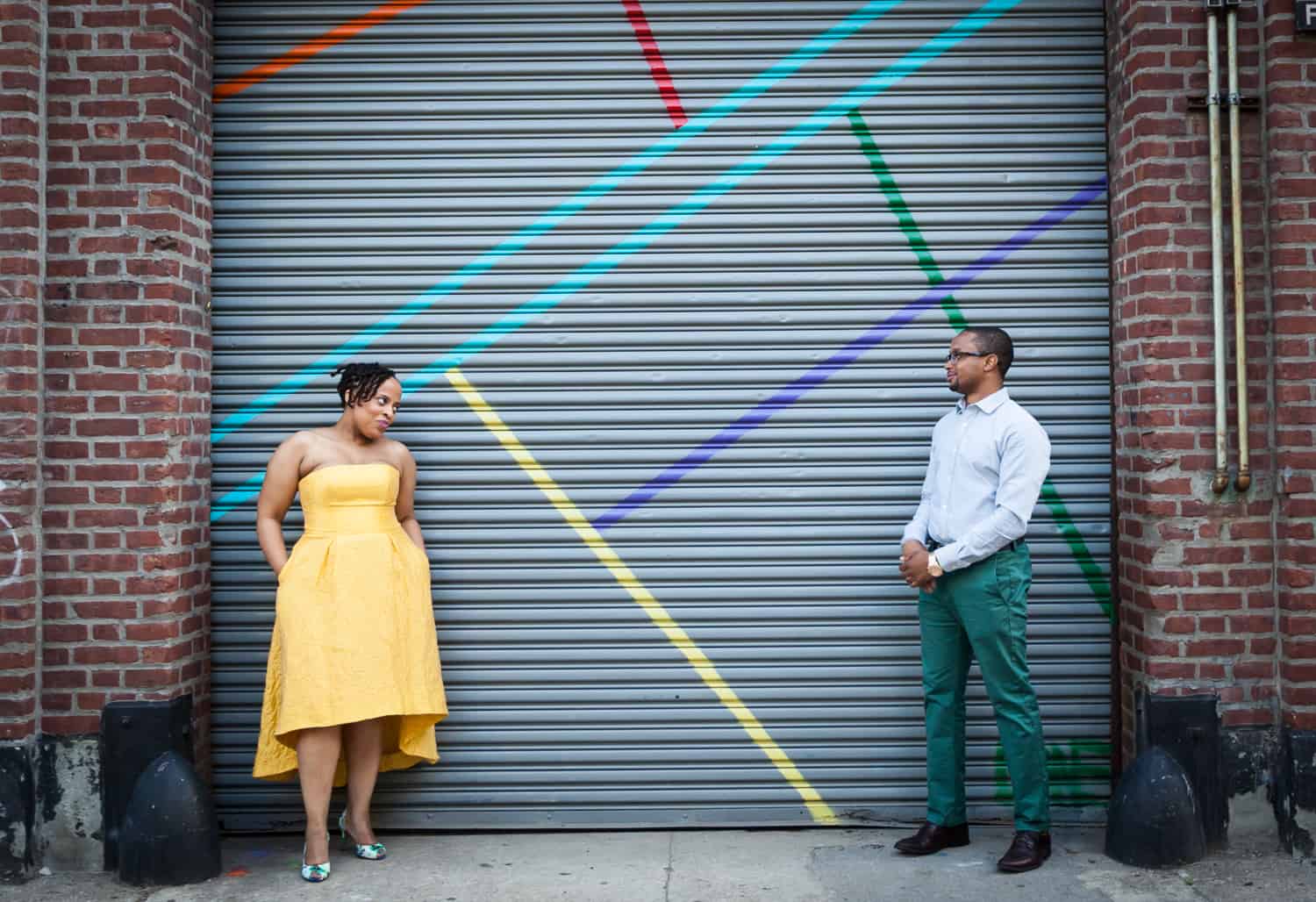 Couple standing in front of metal gate of Five Myles gallery in Brooklyn