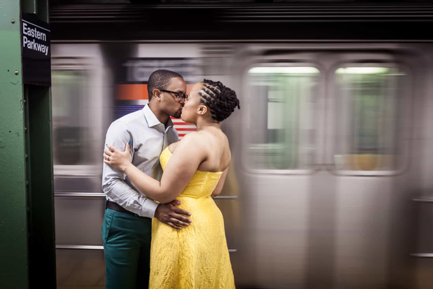 African American couple kissing in front of speeding subway train