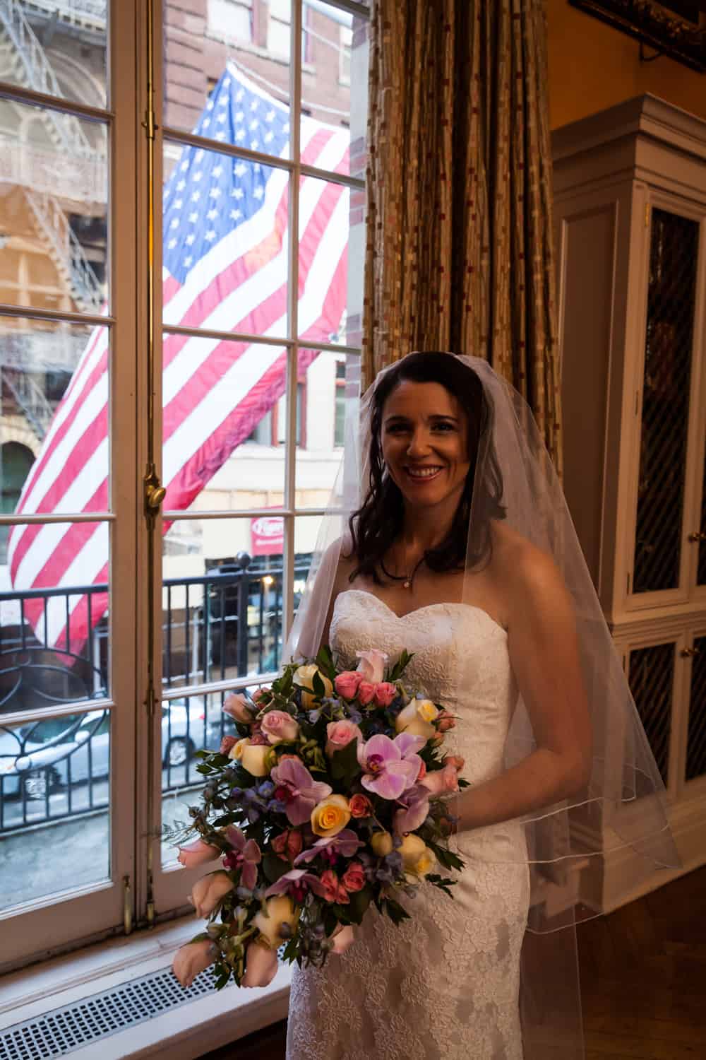 Bride holding bouquet by window for an article on the mysteries of photo editing