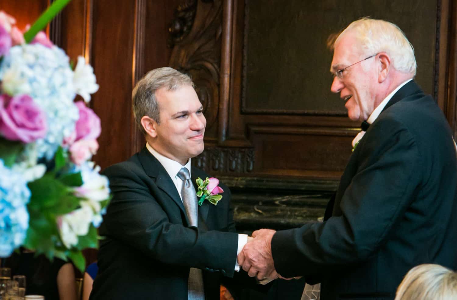 Groom shaking hands with older gentleman at Harvard Club wedding