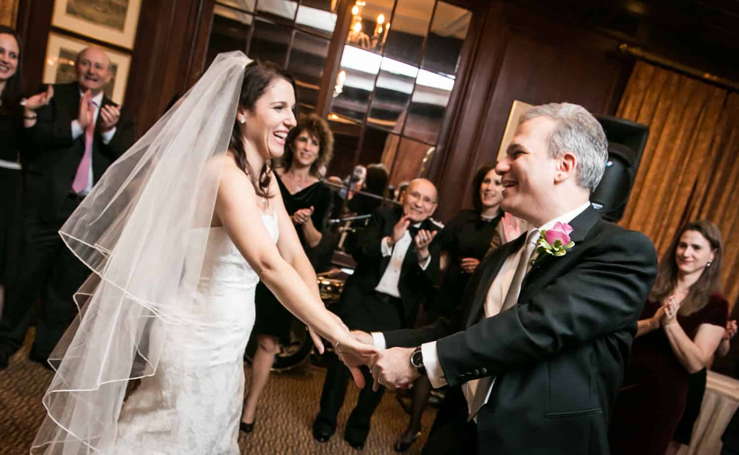 Bride and groom holding hands and dancing the hora at Harvard Club wedding