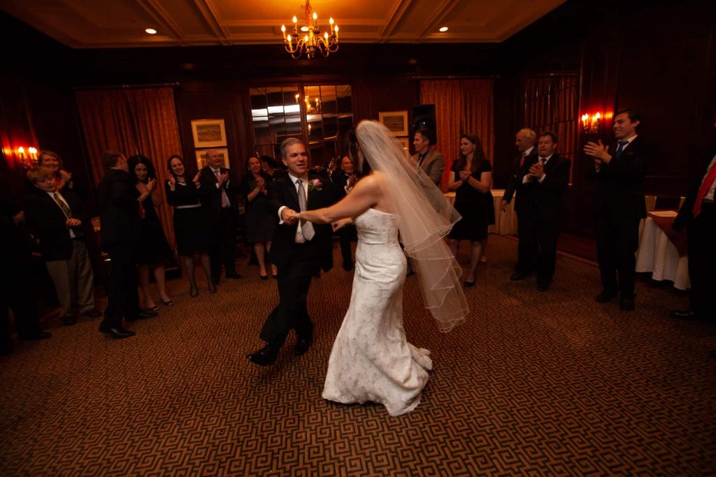 Bride and groom dancing in front of guests for article on the mysteries of photo editing