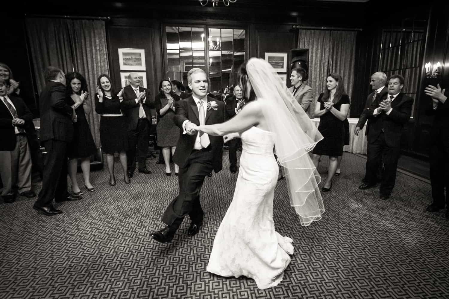 Bride and groom dancing in front of guests for article on the mysteries of photo editing