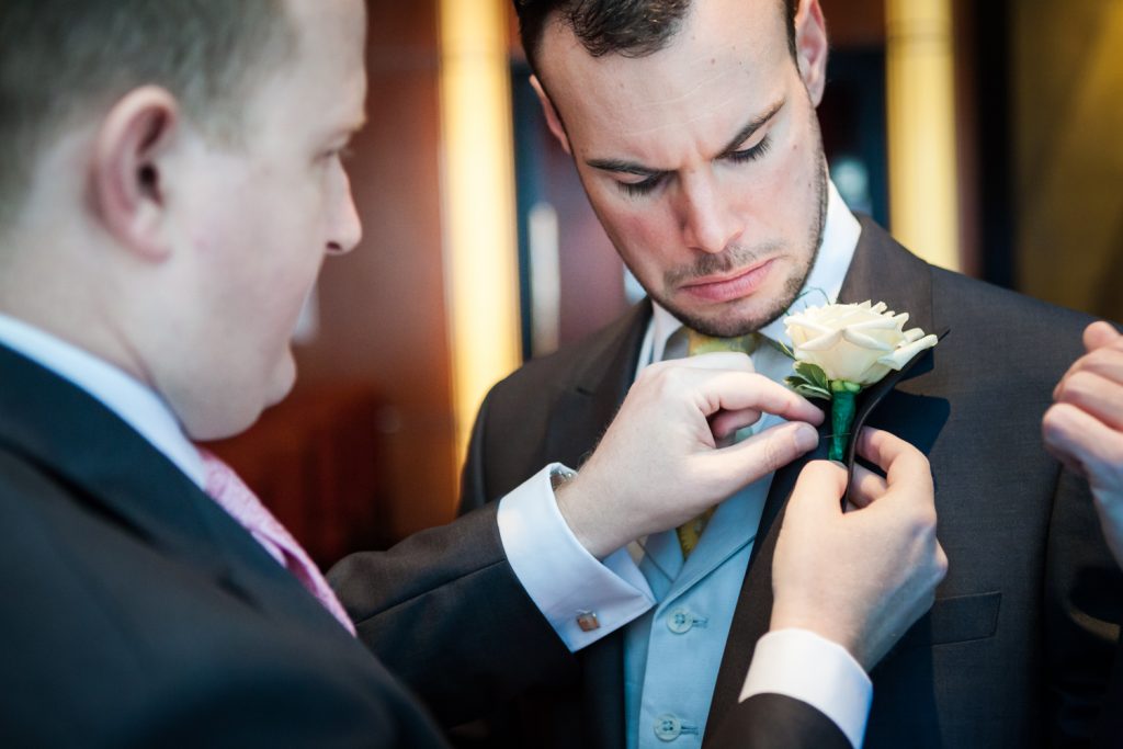 Man putting boutonniere on other man