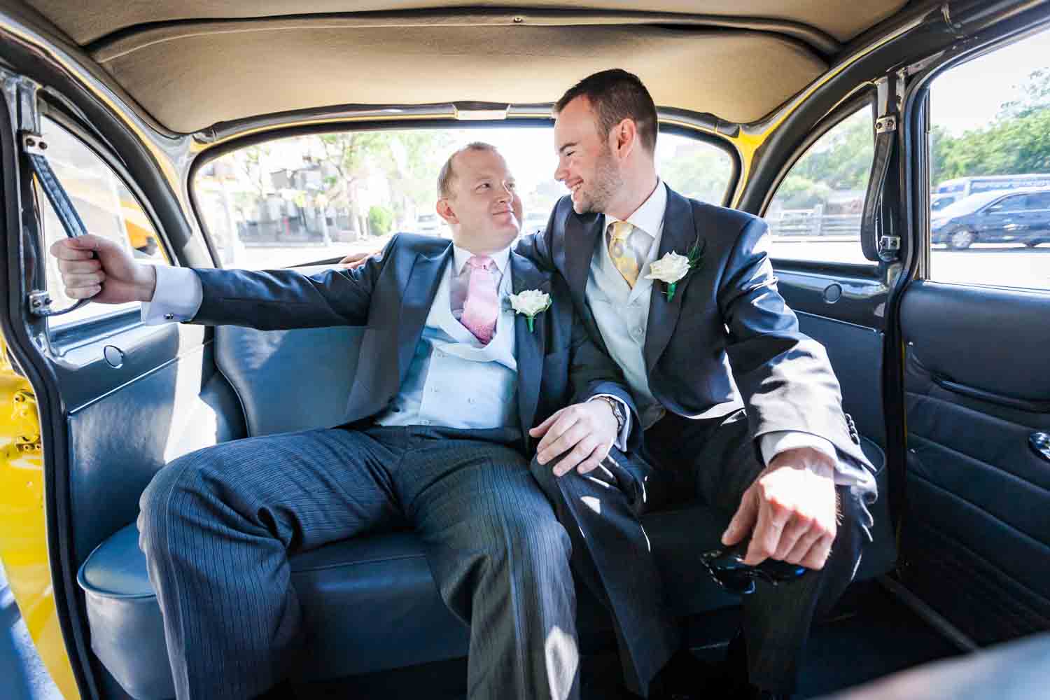 Two men in the back of a taxi cab at an Brooklyn Botanic Garden wedding