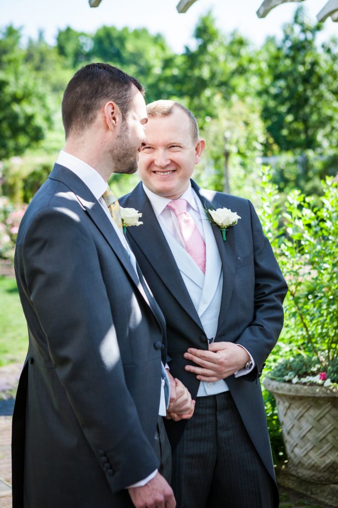 Two grooms looking at each other at an Brooklyn Botanic Garden wedding