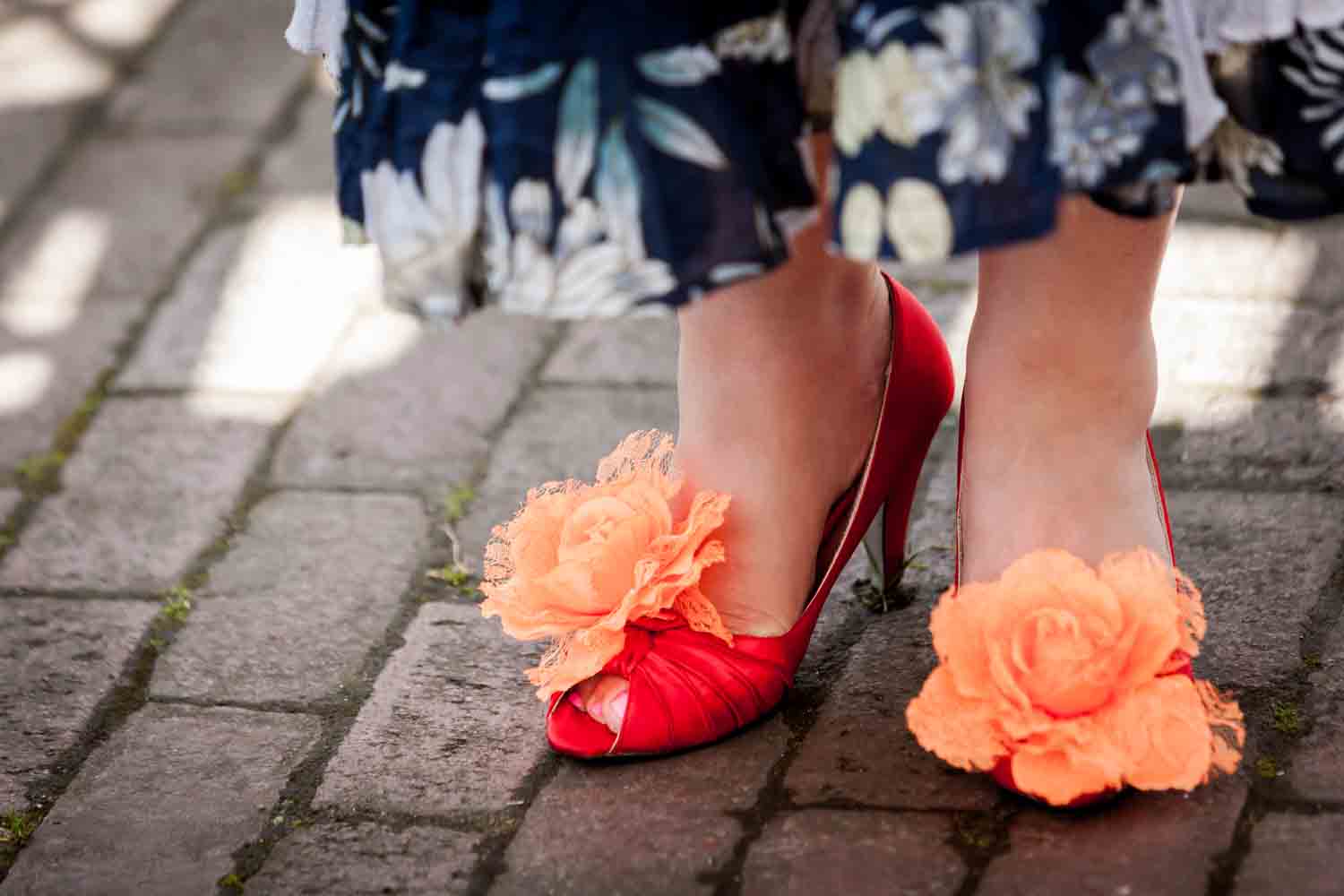 Close up on woman's feet wearing orange shoes with orange flowers