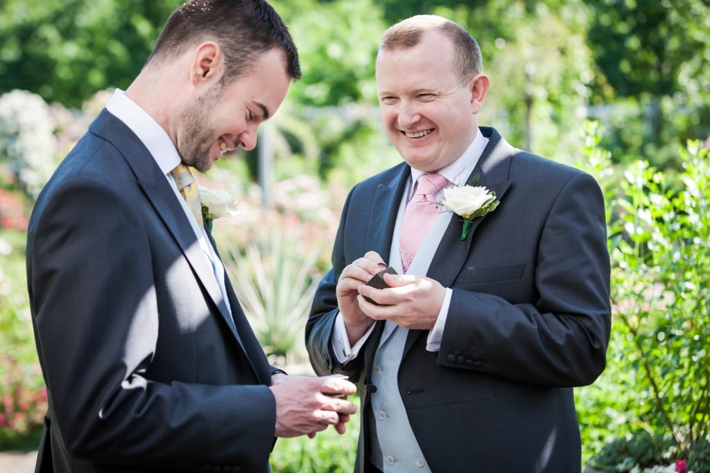 Two grooms holding rings at an Brooklyn Botanic Garden wedding