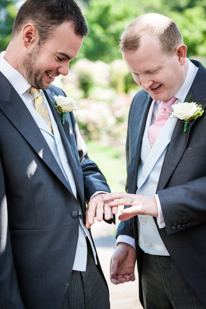 Two grooms looking at wedding rings at an Brooklyn Botanic Garden wedding