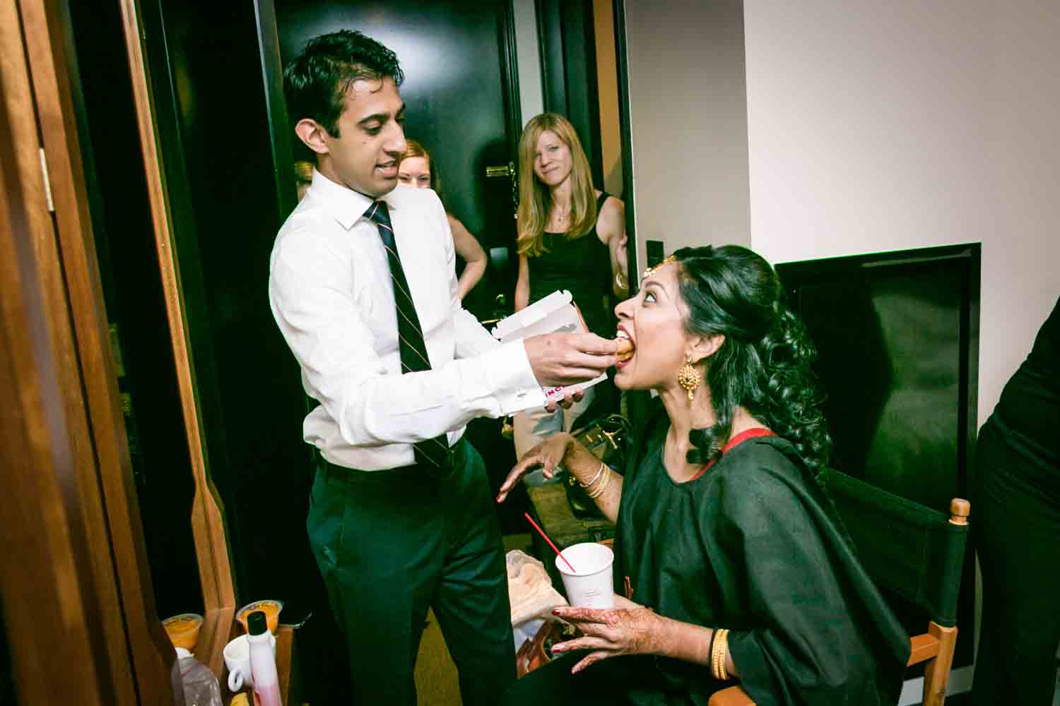 Brother feeding bride while she is getting ready