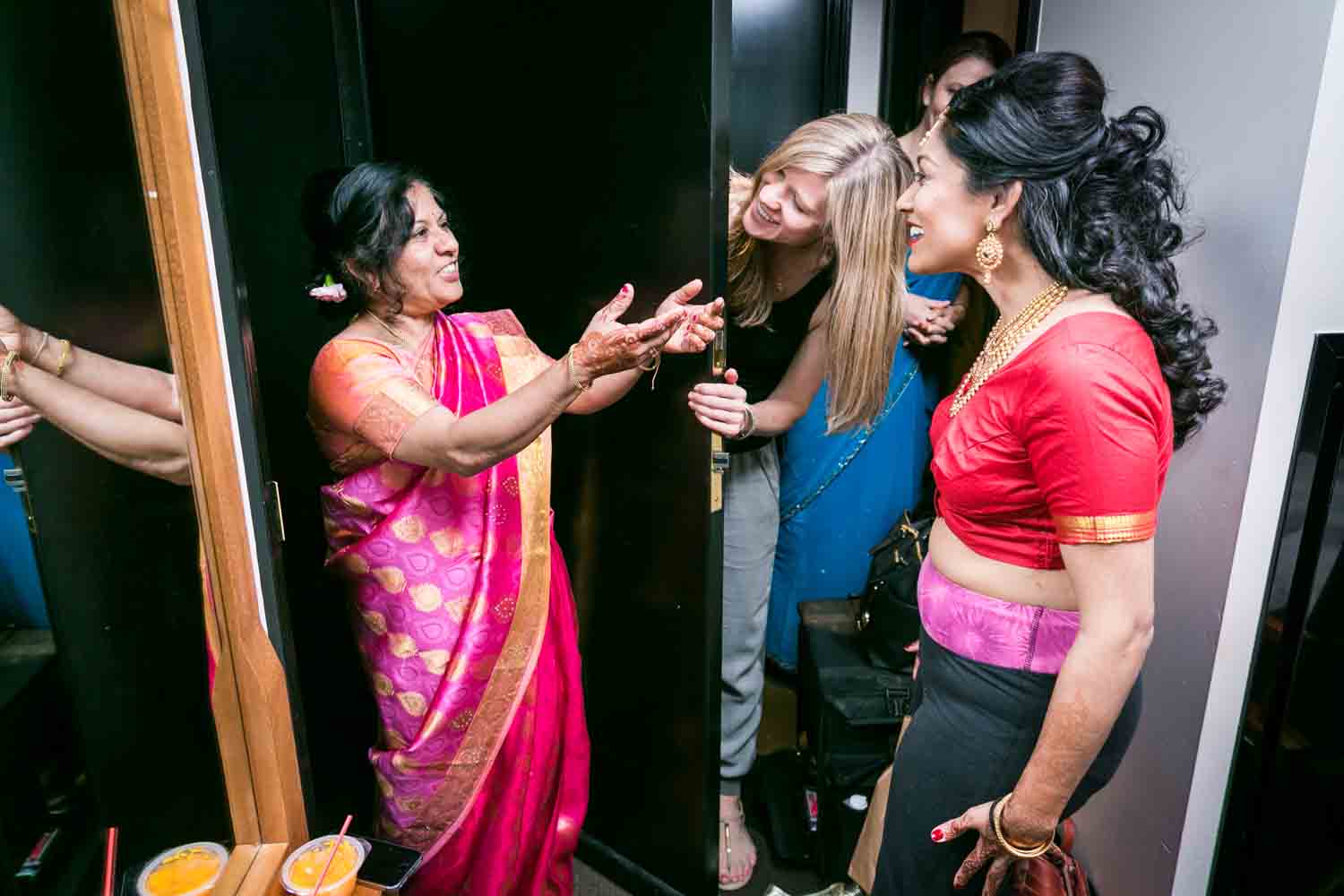 Mother in Indian sari greeting bride and bridal party