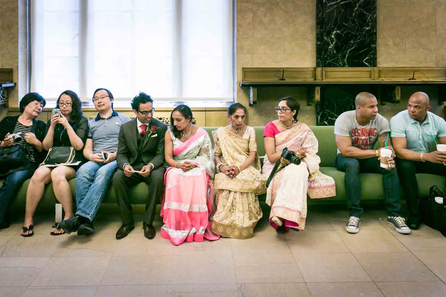 Bridal party wearing traditional saris waiting on bench at a NYC City Hall Indian wedding