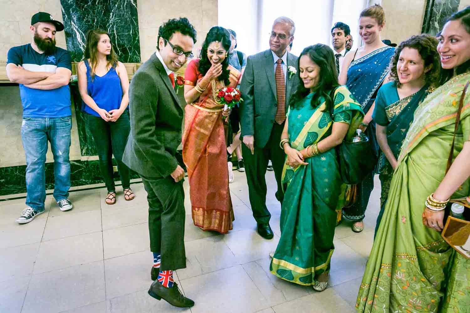 Groom showing off socks in front of bridal party at a NYC City Hall Indian wedding