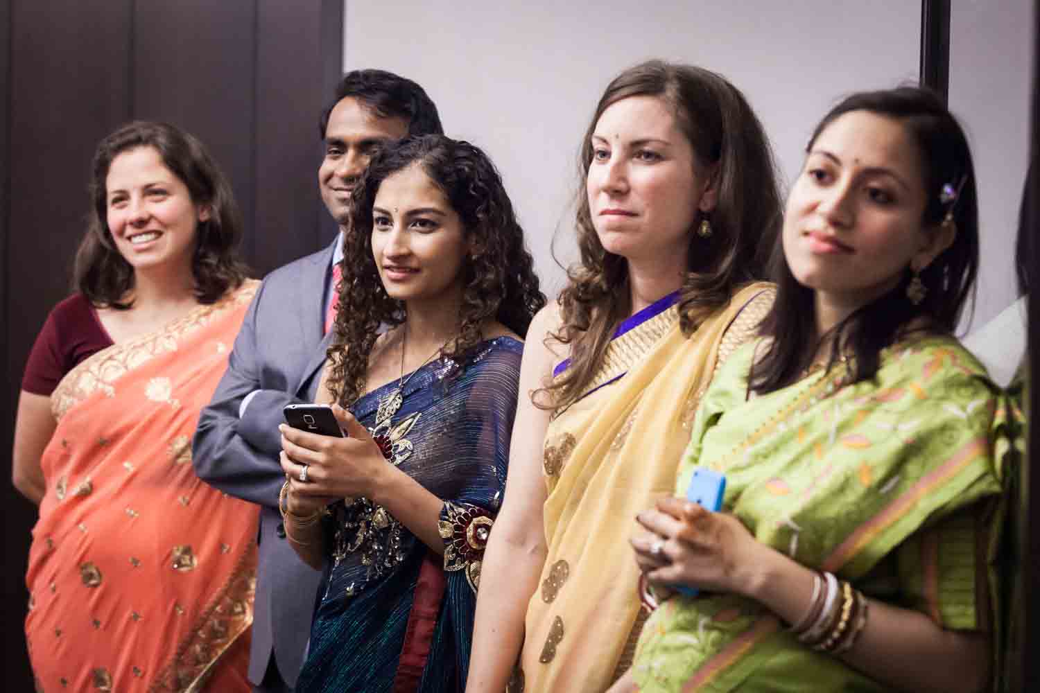 Guests wearing Indian saris listening to ceremony at a NYC City Hall Indian wedding