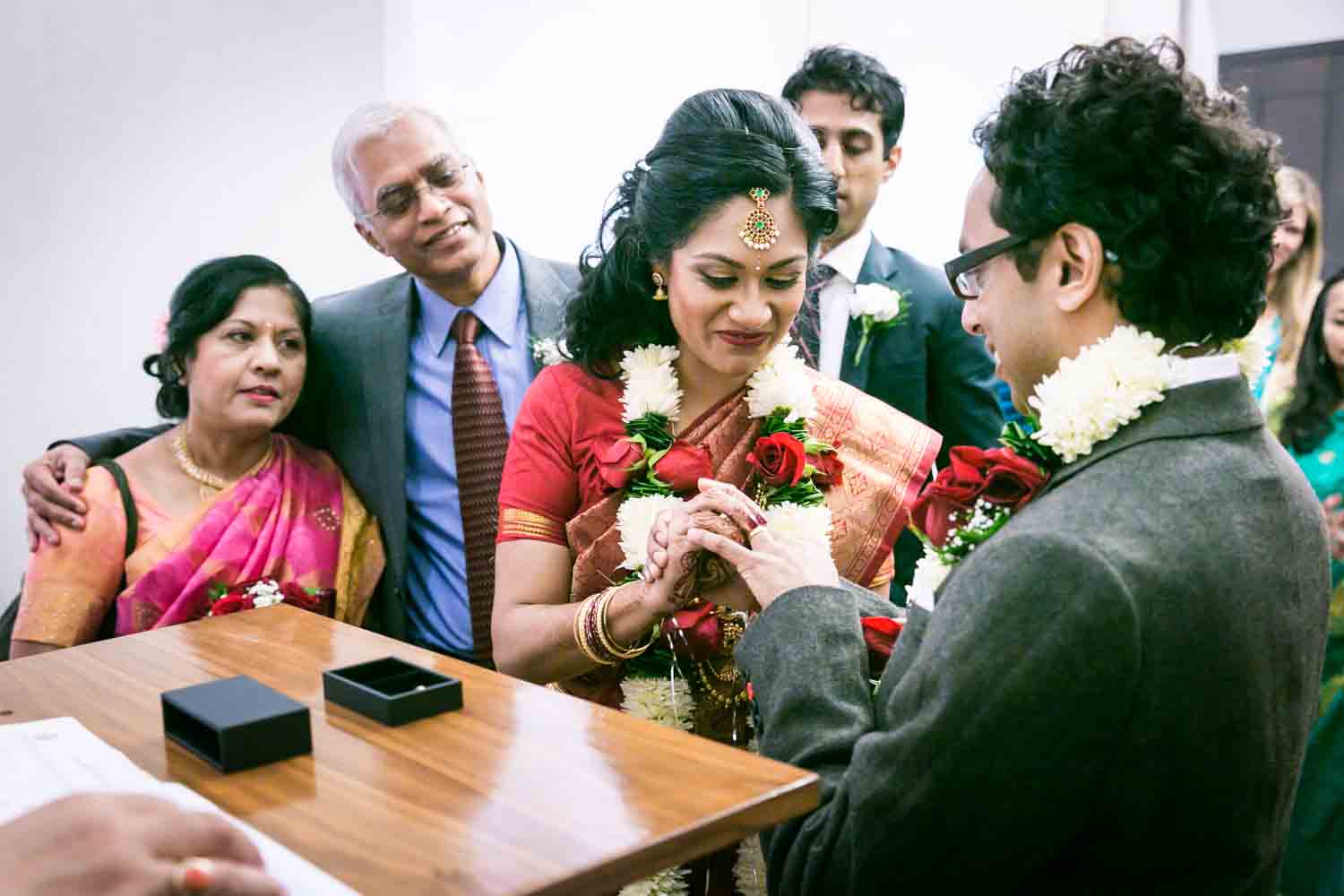 Bride putting ring on groom's finger at a NYC City Hall Indian wedding