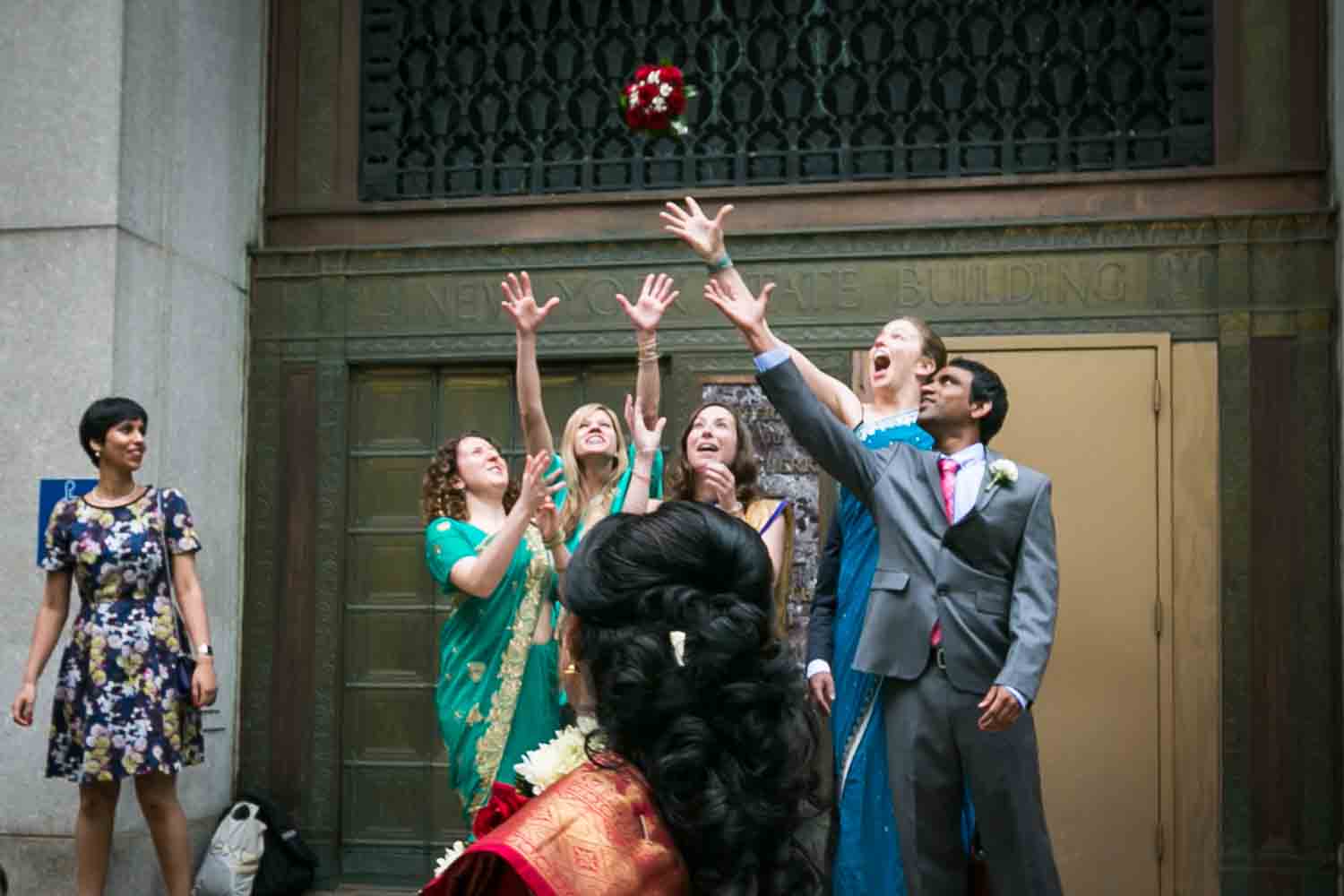 Bridal party wearing Indian saris and catching bouquet at a NYC City Hall Indian wedding