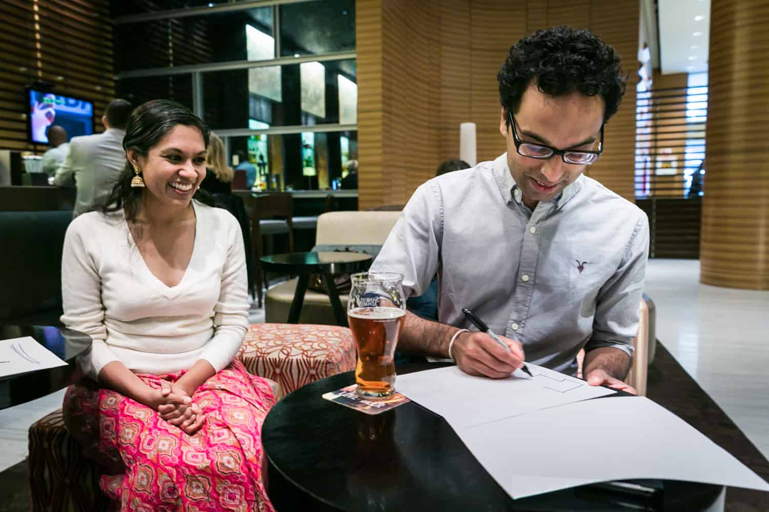 Woman watching as man makes 'thank you' sign at table