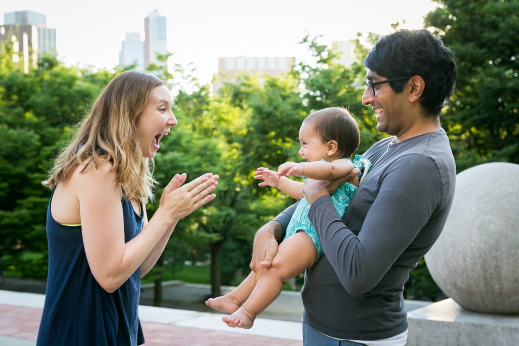Little toddler playing with her parents during Fort Greene Park family portrait