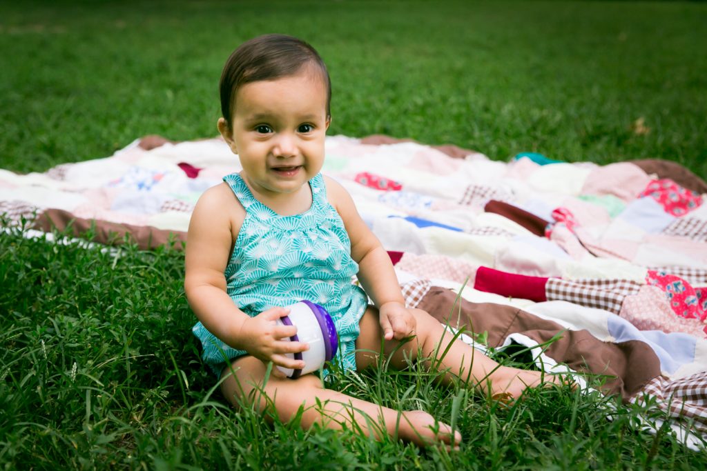 Baby playing with toy in grass