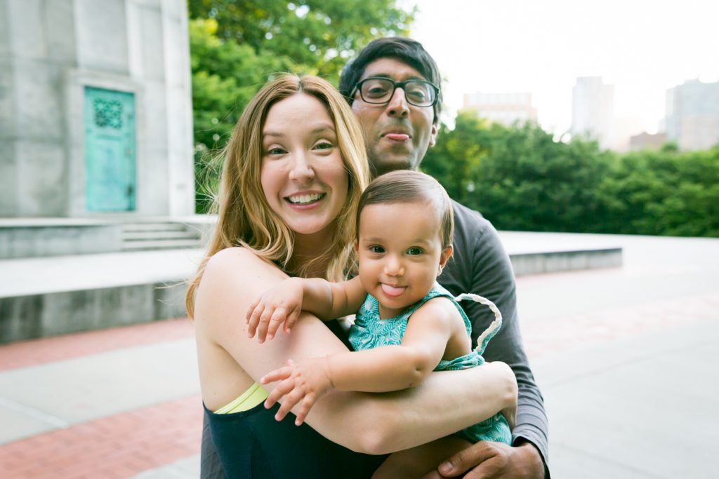 Parents and baby making faces during Fort Greene Park family portrait session