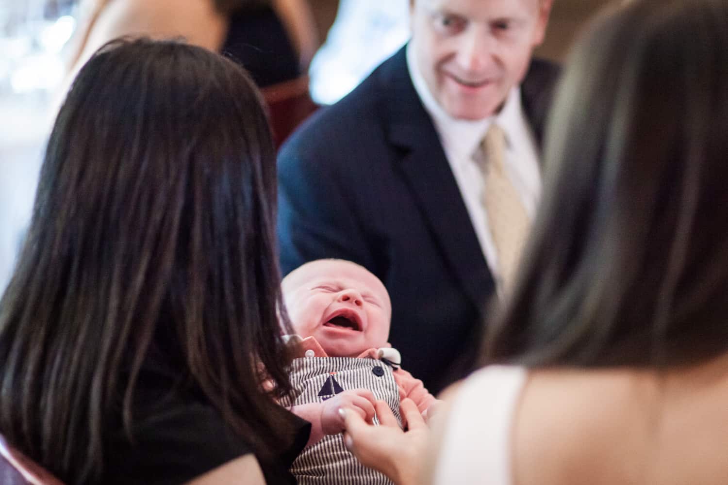 Guests focused on a crying baby at a Hoboken rehearsal dinner