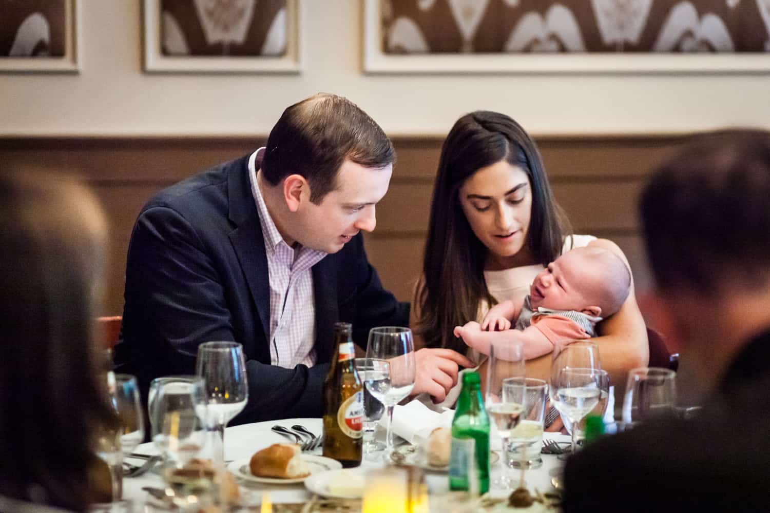 Couple focused on a crying baby at a Hoboken rehearsal dinner