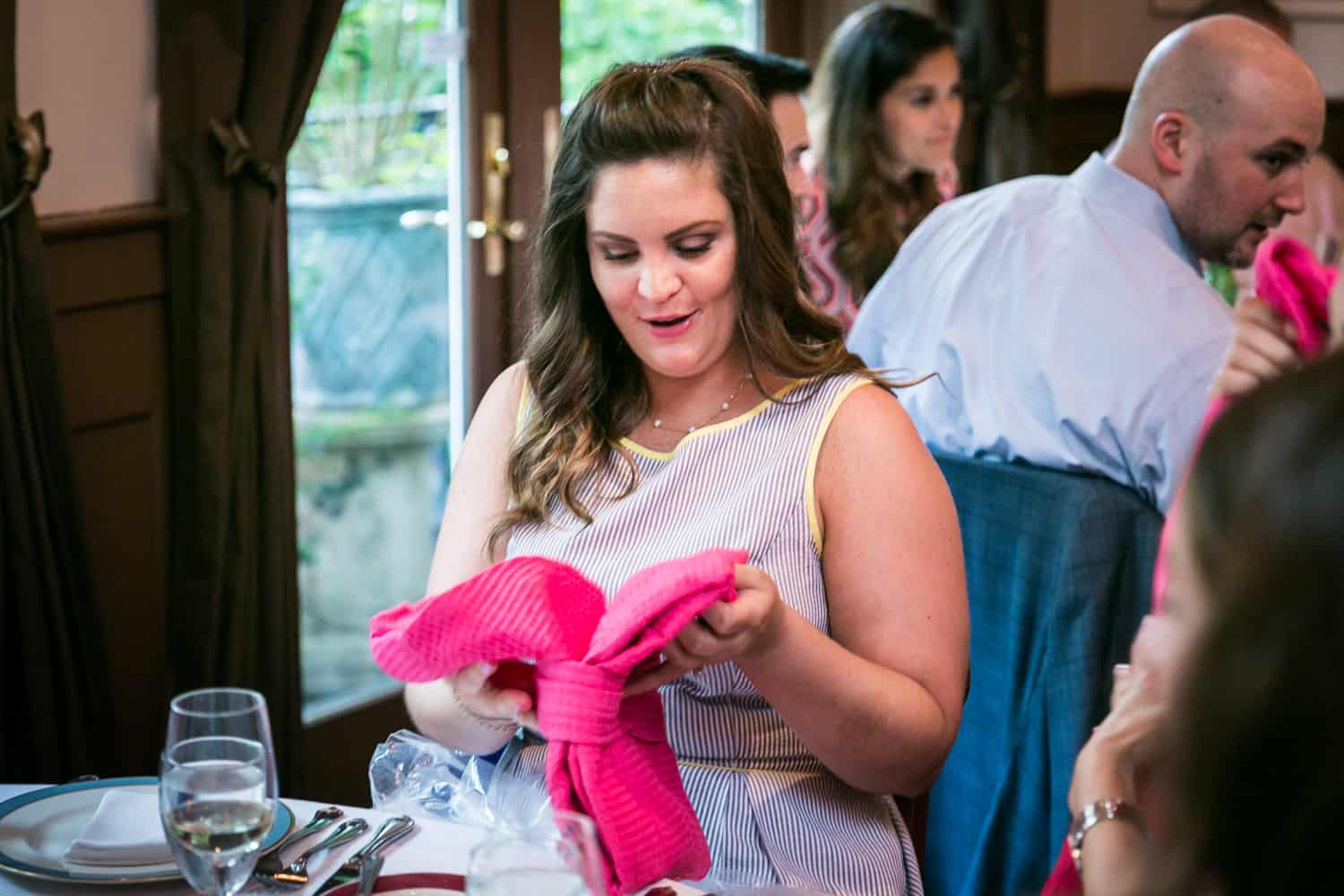 Female guest opening gift at a Hoboken rehearsal dinner